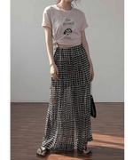 ピンクのグラフィックTシャツをウエストで結び、ハイウエストドット柄ワイドパンツを合わせた、リラックス感のある夏のレディースコーディネート。