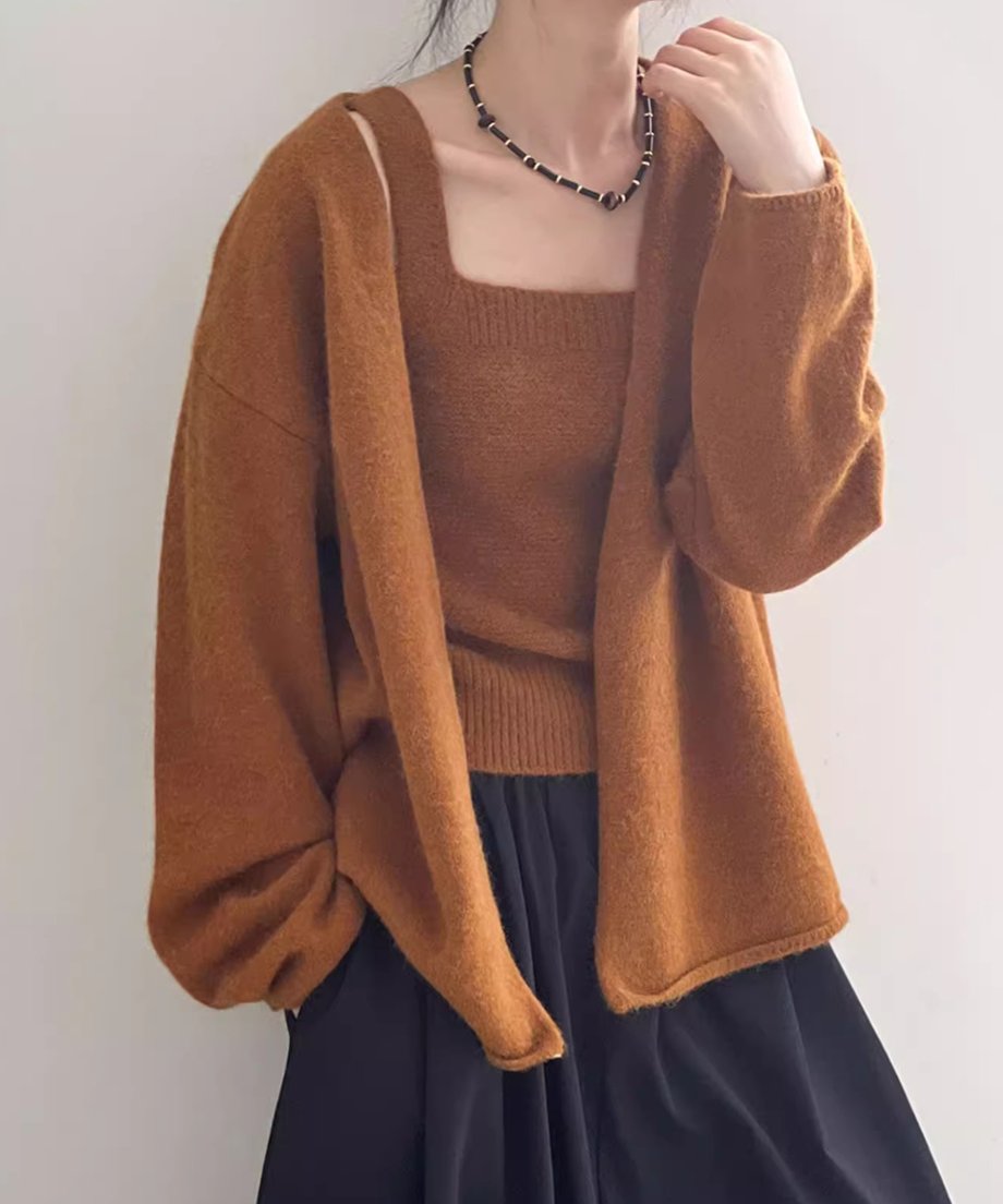 キャメルのニットキャミソールにカーディガンを肩に落として羽織った女性の半身像。黒いロングスカートと太めのネックレスを着用。