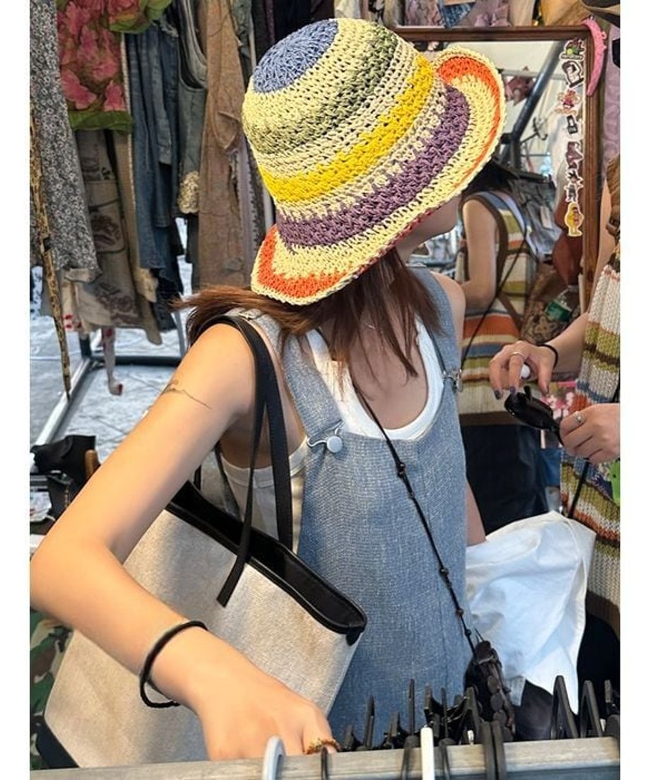 ブルーのワイドレッグオーバーオールとマルチカラーのハットを合わせた、夏のアウトドアシーンを想起させるスタイリング。