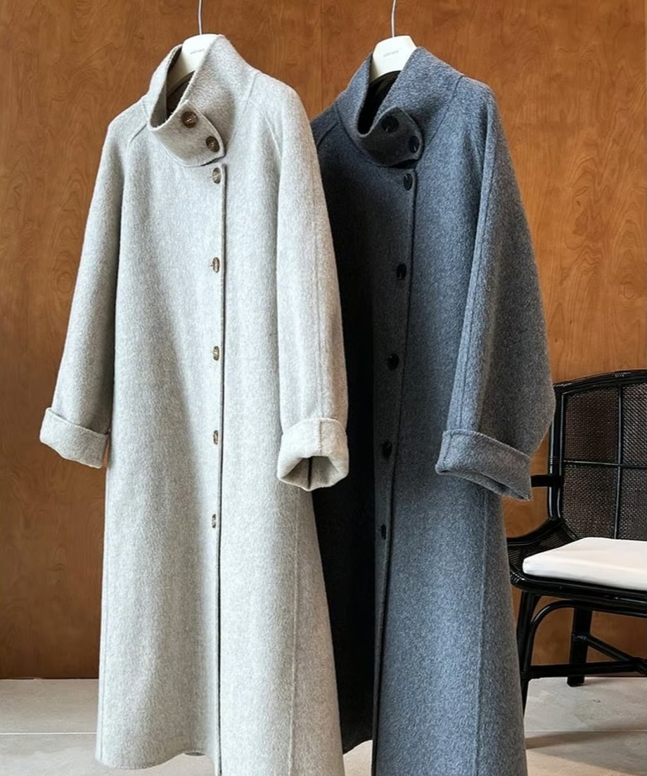 モカととダークグレーのスタンドカラーコート2着をハンガーにかけた商品写真。襟元のボタンとロールアップされた袖口が見える。