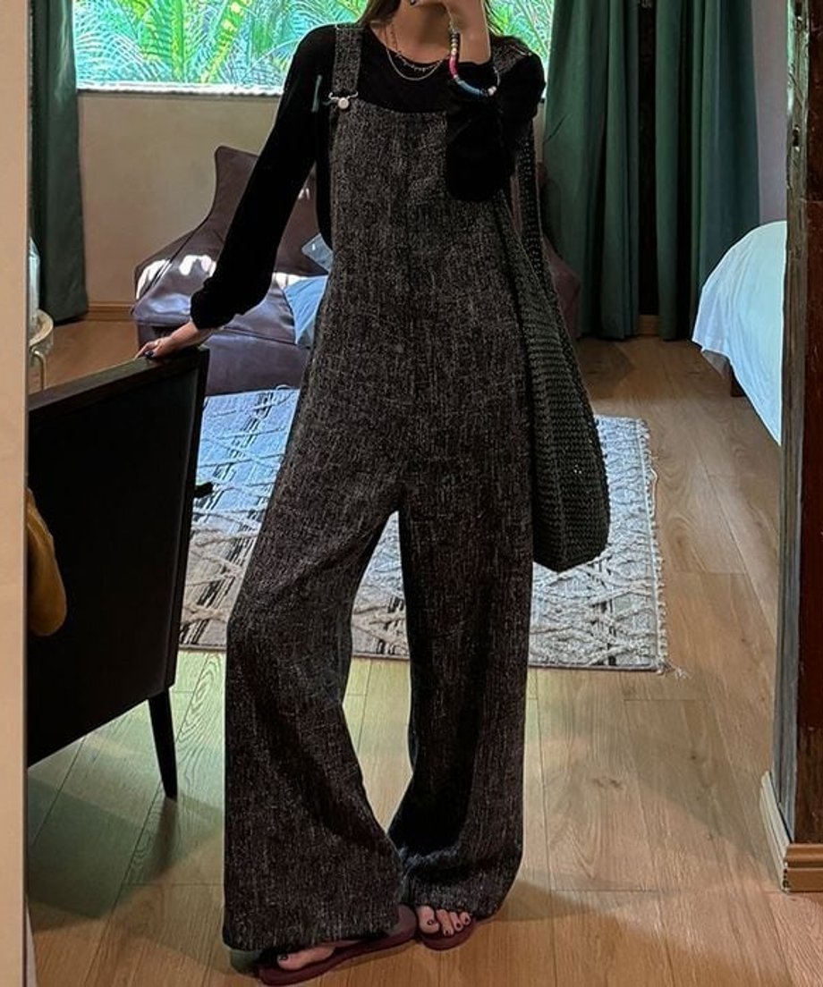 鏡越しの全身カット。すとんと落ちるワイドレッグのシルエットが際立つ、ブラックのオーバーオールコーディネート。
