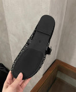 黒いメッシュスリッポンの靴裏を、持っているアップ画像。靴底にはサイズ表記が見える。