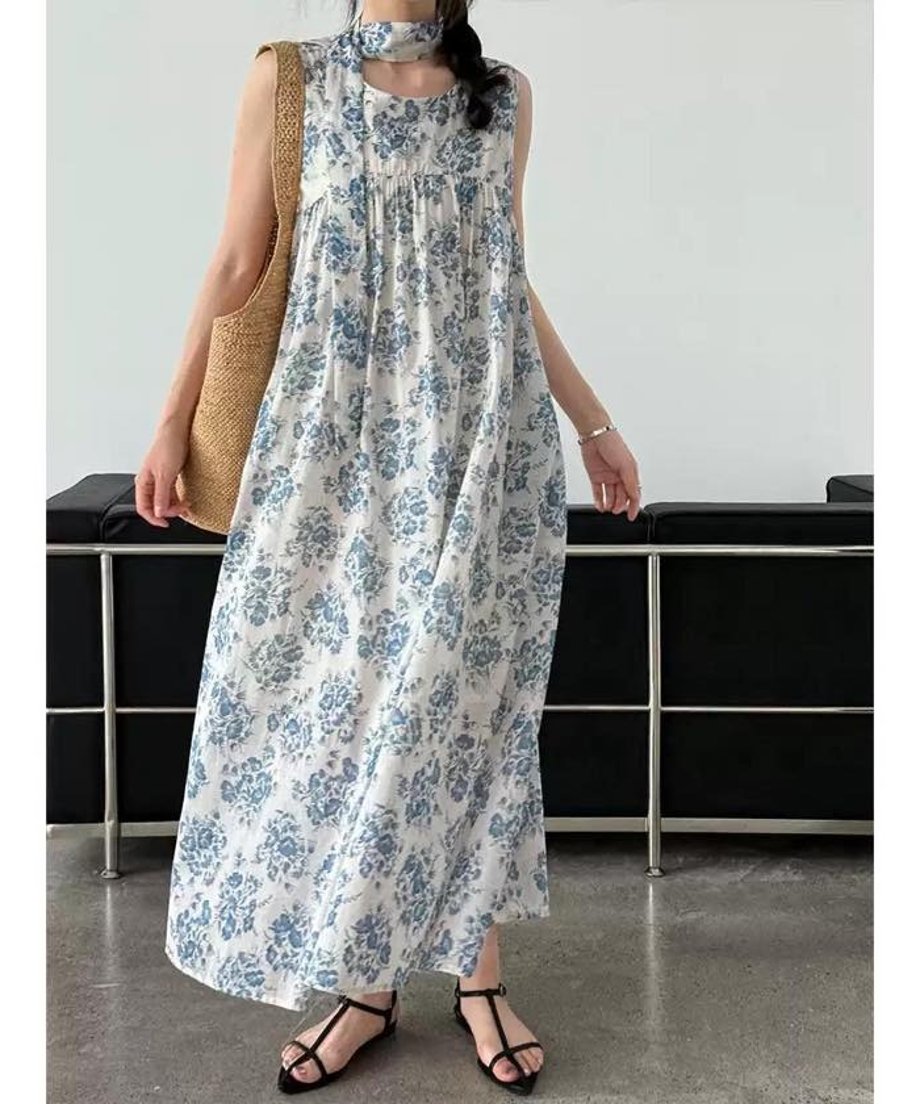 ブルーフラワーワンピースを着用した女性がスカーフのようにリボンを首に巻いている写真