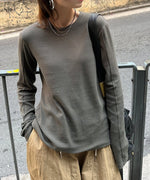 グレーのアウトシームロングTシャツを着て、ベージュのドローストリングパンツを着用した人物のバストアップ。