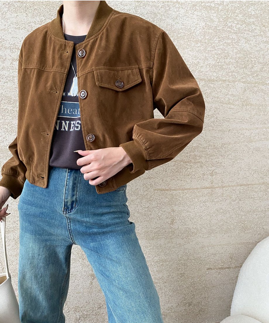 キャラメルのフェイクスエードジャケットを着用した上半身。ロゴTシャツとブルーデニムを合わせ、ジャケットの素材感と胸ポケットのディテールがよく見える。