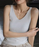 白いリブタンクトップを着た女性がシンプルなアクセサリーを身につけている画像。