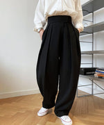 ブラックのハイウエストワイドタックパンツを白いシャツにタックインし、白いスニーカーを合わせた全身コーディネート。