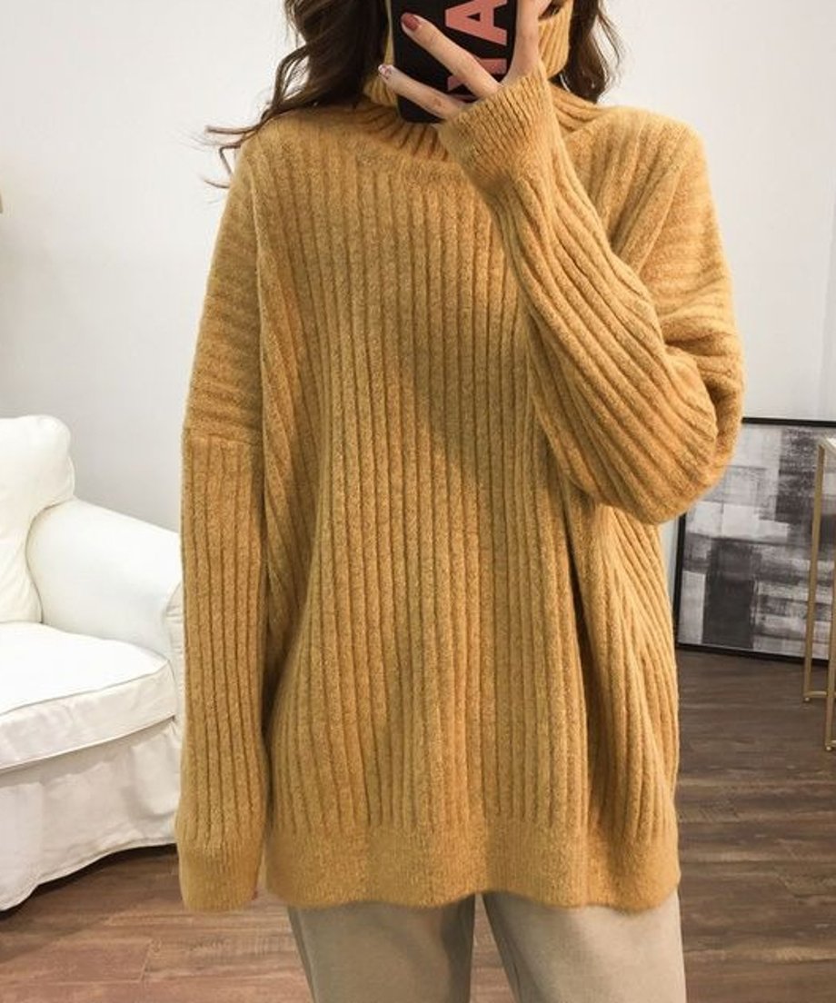 イエローのオーバーサイズタートルネックニットを着用した女性の上半身。太めのリブ編みとゆったりとした袖口が特徴。