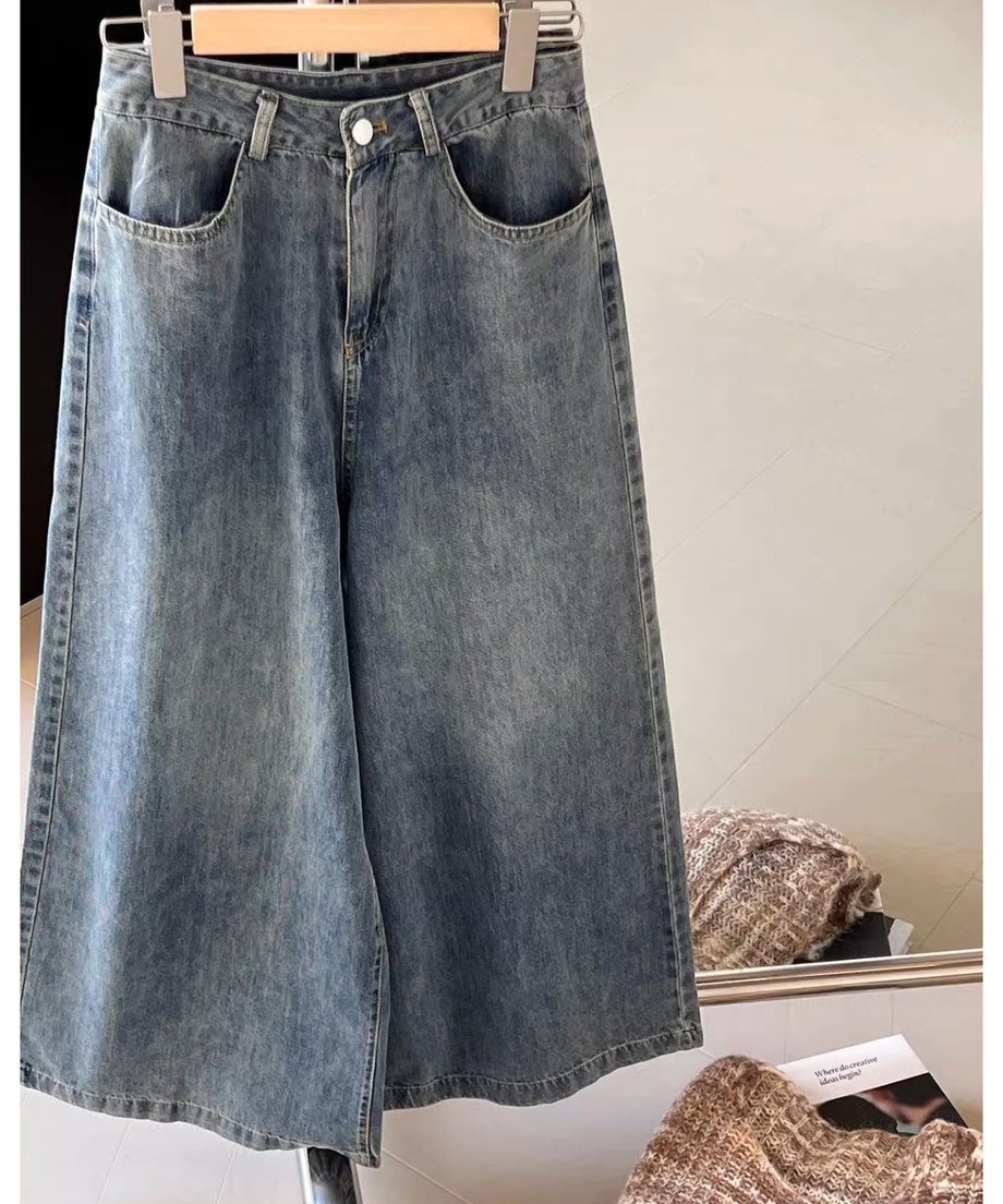 ハンガーに掛けられたワイドレッグデニムパンツのクローズアップ。