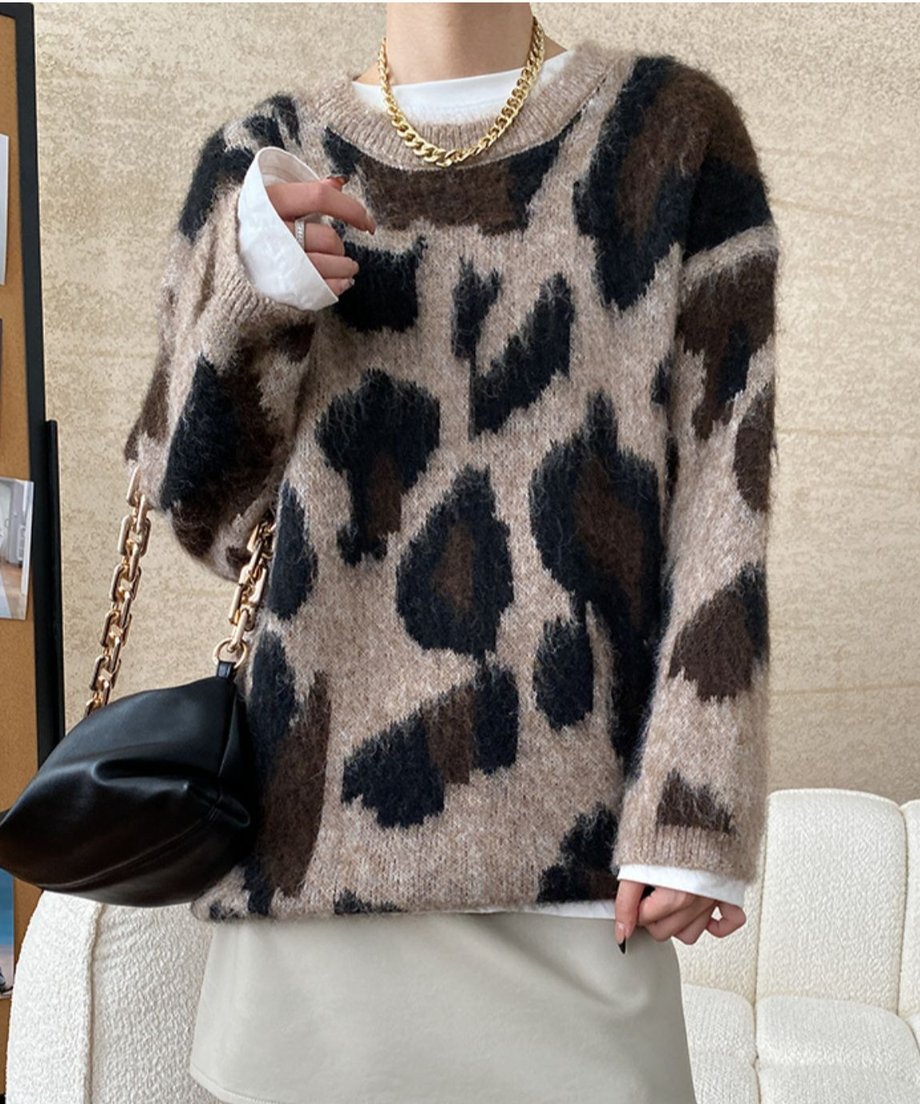 ブラウンの系レオパード柄のモヘア調ニットを着用し、ゴールドのネックレスと黒のチェーンバッグを合わせた女性の上半身。