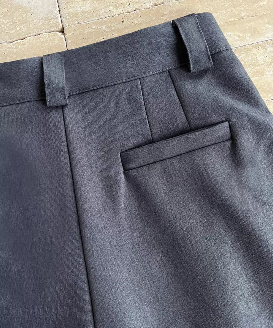 グレーのタックワイドパンツのヒップ部ポケットのクローズアップ。
