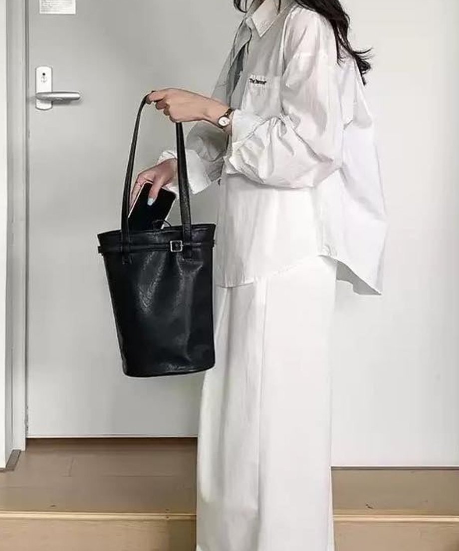 ブラックのバケットバッグを肩にかける横向きの画像。