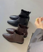 白い背景に、濃いブラウンのレザー調チェルシーブーツと黒のブーツ、2足置かれている。