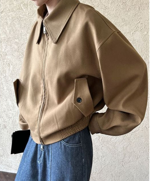 ブラウンのドロップショルダーブルゾンを着用した女性の横からのショット。ドロップショルダーとボリューム感のある袖が特徴的。