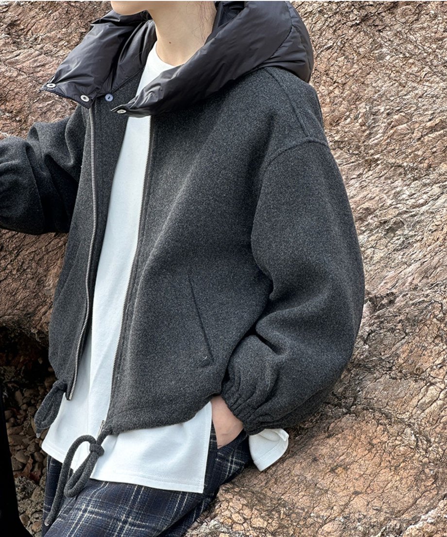 ブルゾンの上半身アップ画像。ファスナーを開け、インナーの白Tシャツを見せたレイヤードスタイル。