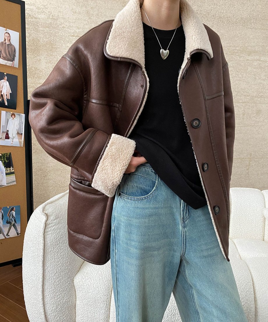 コーヒー色のエコレザー面を表にして着用した女性の上半身画像。襟と袖口の白いボアがアクセントになっている。