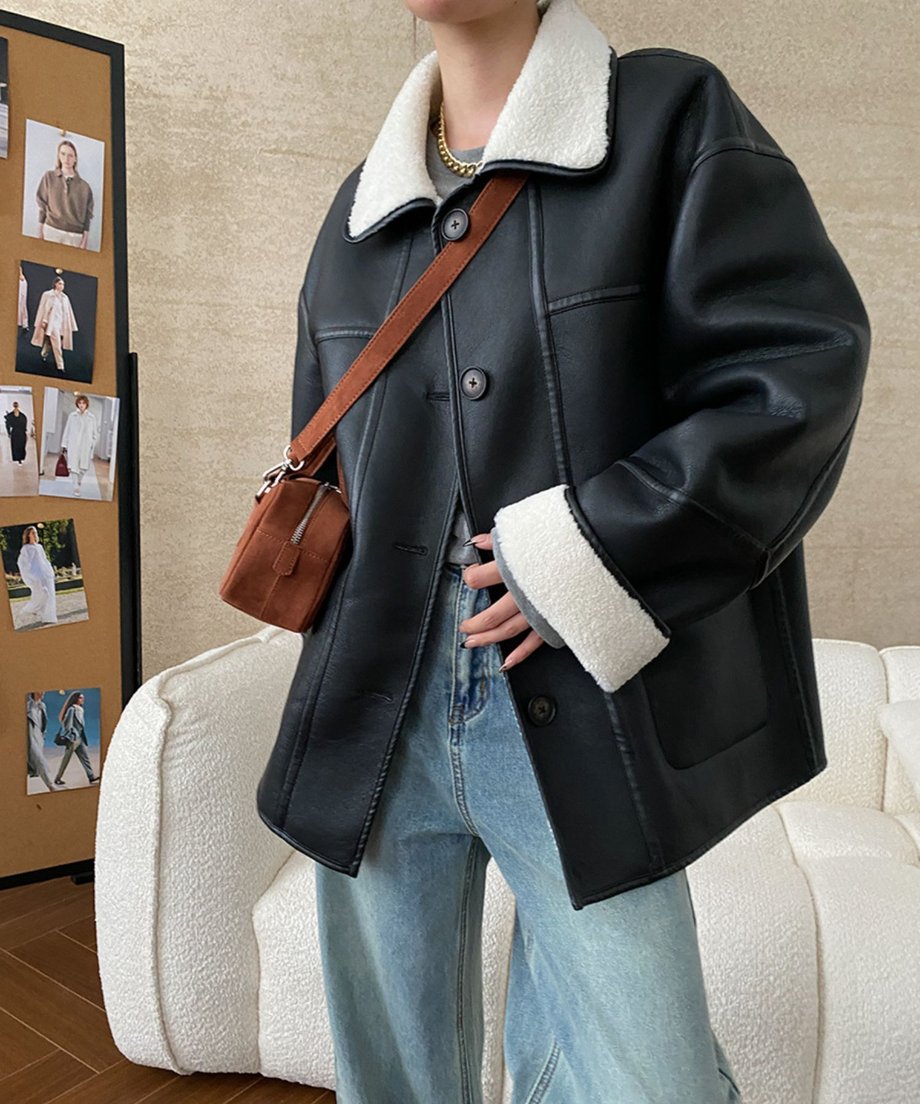 ブラックのエコレザージャケットを着用し、ポケットに手を入れている女性の正面アップ画像。
