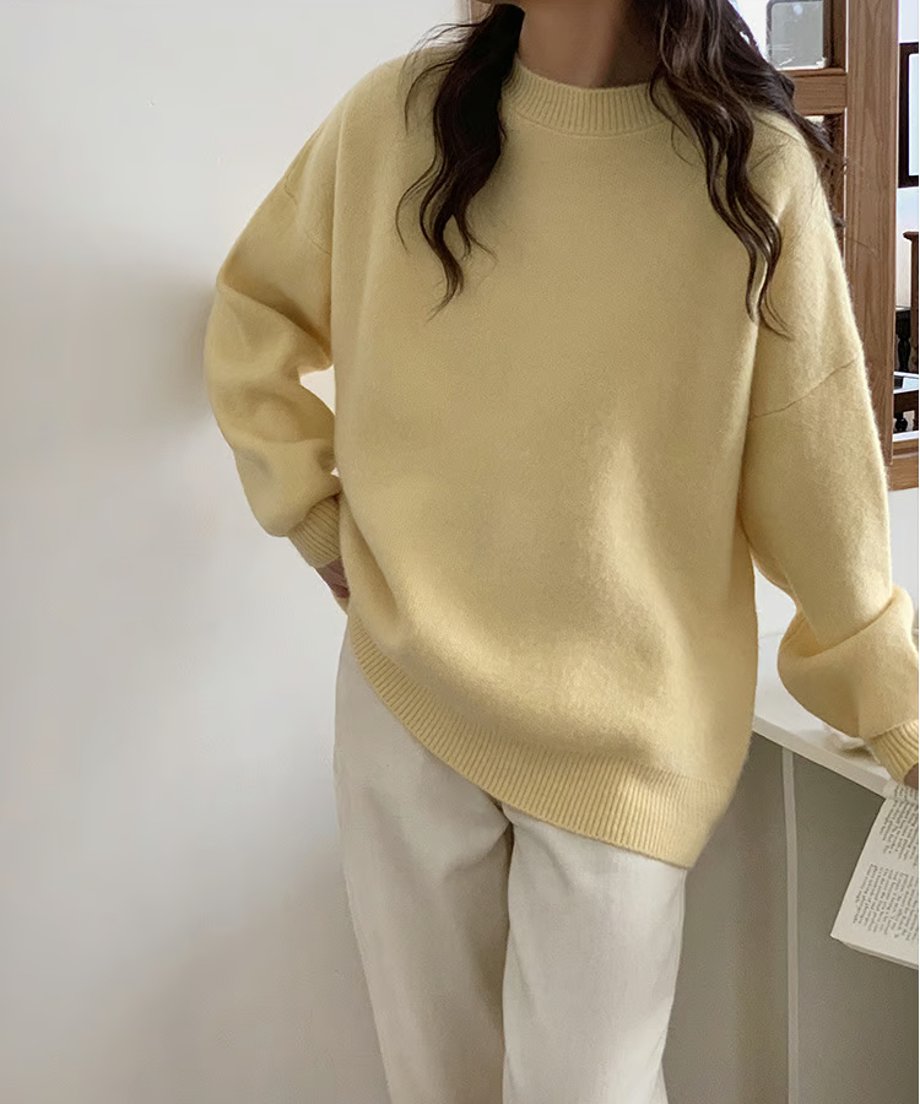 イエローのニットプルオーバーを白いパンツに合わせた、明るく爽やかな秋冬コーディネート。