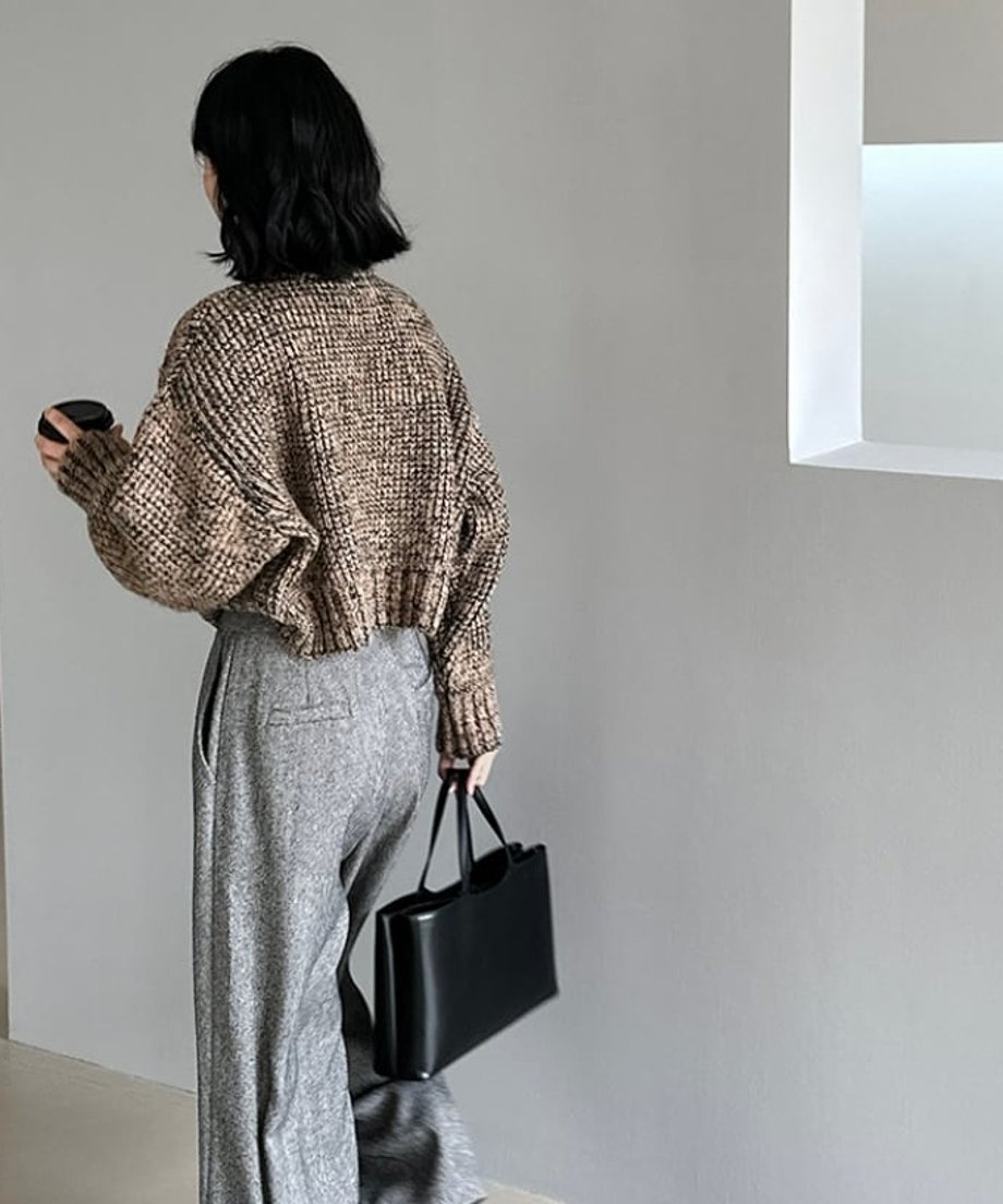 ブラウンミックスのショート丈ニットとグレーのワイドパンツを着用した人物の、後姿の全身ショット。