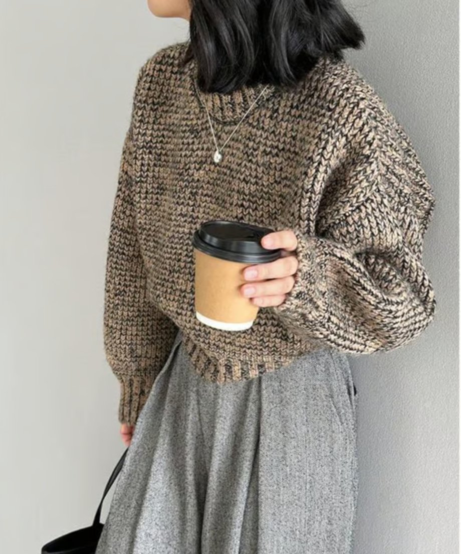 ブラウンミックスのショート丈ニットとグレーのワイドパンツを着用した人物の、正面からのバストアップ。