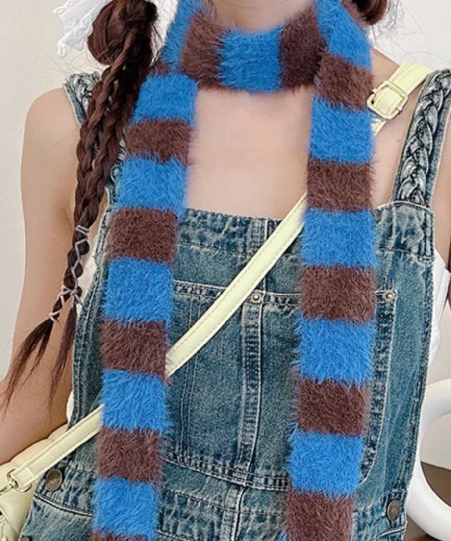 ブルーとコーヒーのストライプ柄ロングマフラーを首に巻いた状態の、上半身のクローズアップ写真。