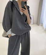 グレーのボタン付きオーバーサイズフーディーとワイドパンツのセットアップを着用した全身像。白いインナーをレイヤードし、鏡で自撮りしているカジュアルなコーディネート。