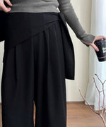 ブラックのワイドレッグパンツのウエスト部分のクローズアップ画像。ウエストにスカーフを巻いたデザインが印象的。