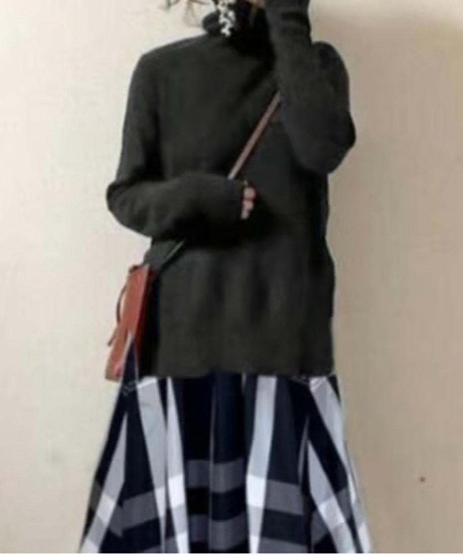 ダークトーンのハイネックニットトップス部分。ゆったりとした袖口と、茶色のミニショルダーバッグを着用。