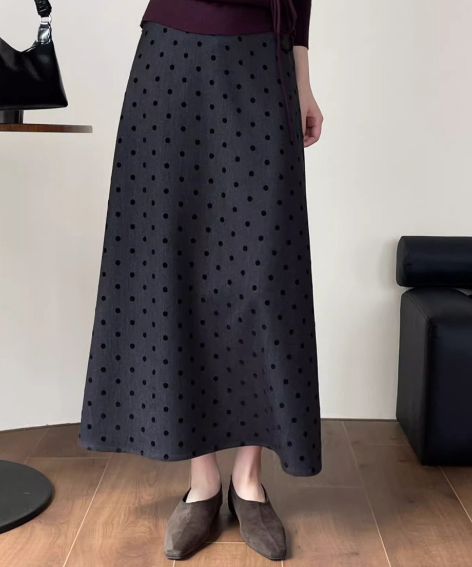 グレー地に黒ドット柄のAラインスカートに、茶系のスエードフラットシューズを合わせたコーディネートの膝下ショット。