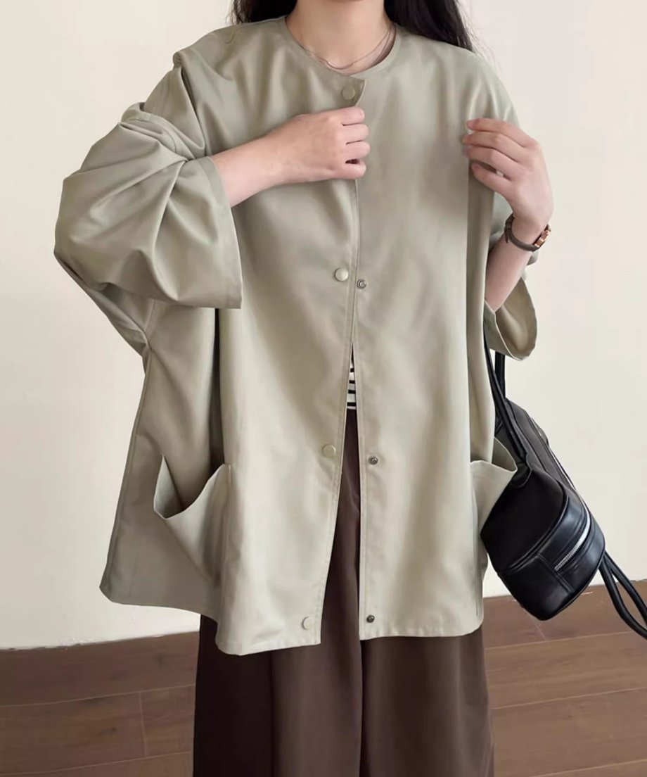ノーカラーショートコートにボーダー柄のインナーとブラウンのワイドパンツを合わせた女性。
黒いバッグを持っている。