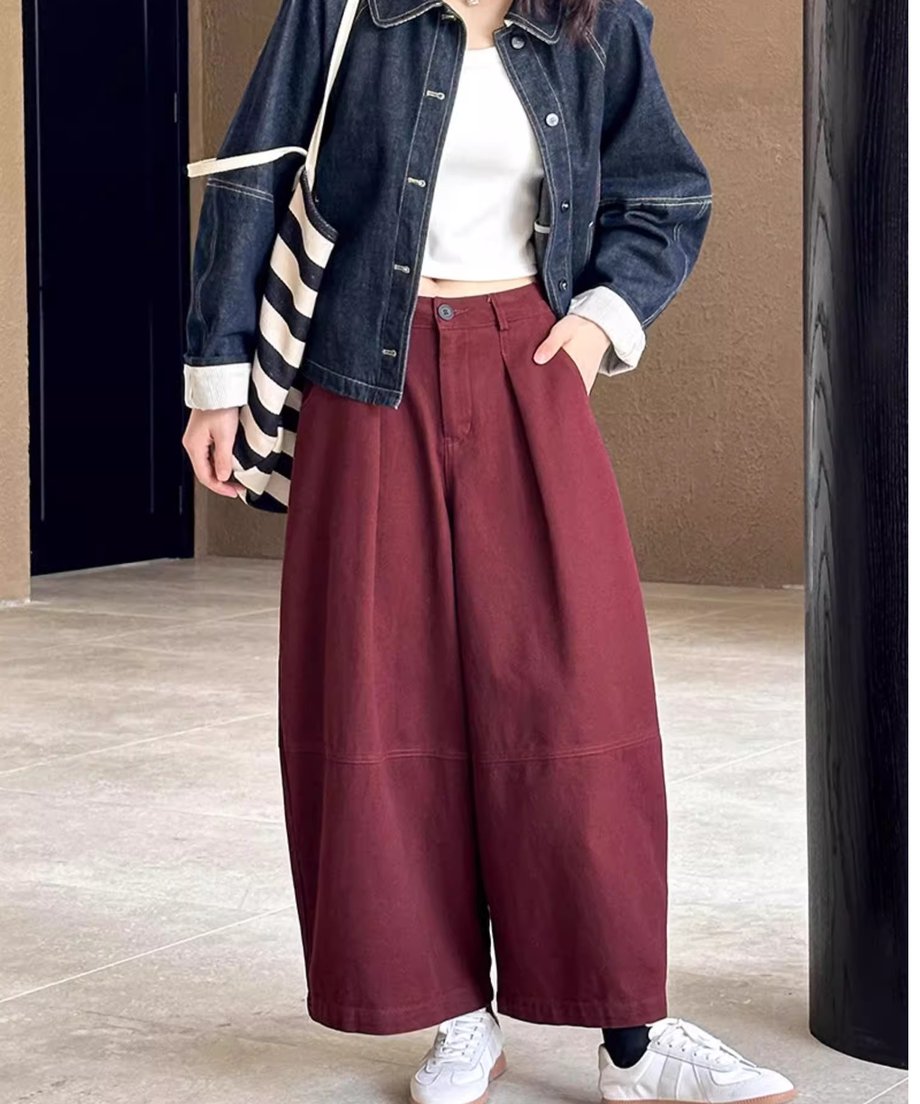ボルドーのワイドパンツの着用画像。白と黒のボーダー柄のトートバッグを手に持ち、デニムジャケットを羽織っている。