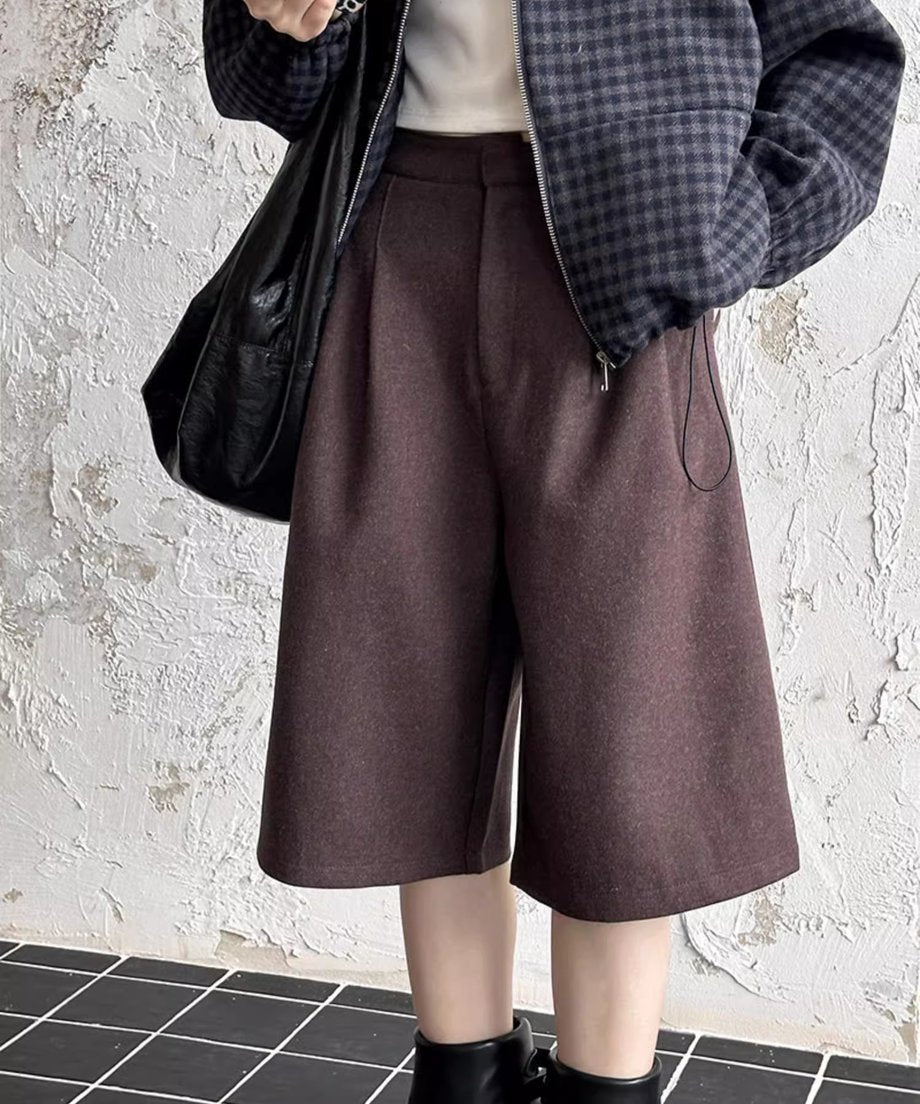 ブラウンのワイドハーフパンツとチェック柄ブルゾン、黒の筒型ブーツを合わせた半身カット。