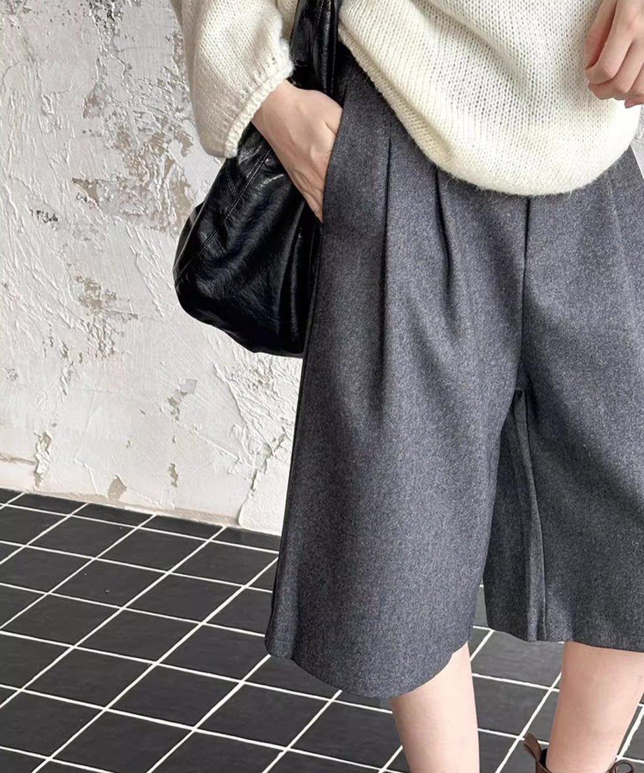 グレーのワイドハーフパンツのフロントのディテール。深いタックが入っているのが確認できる。