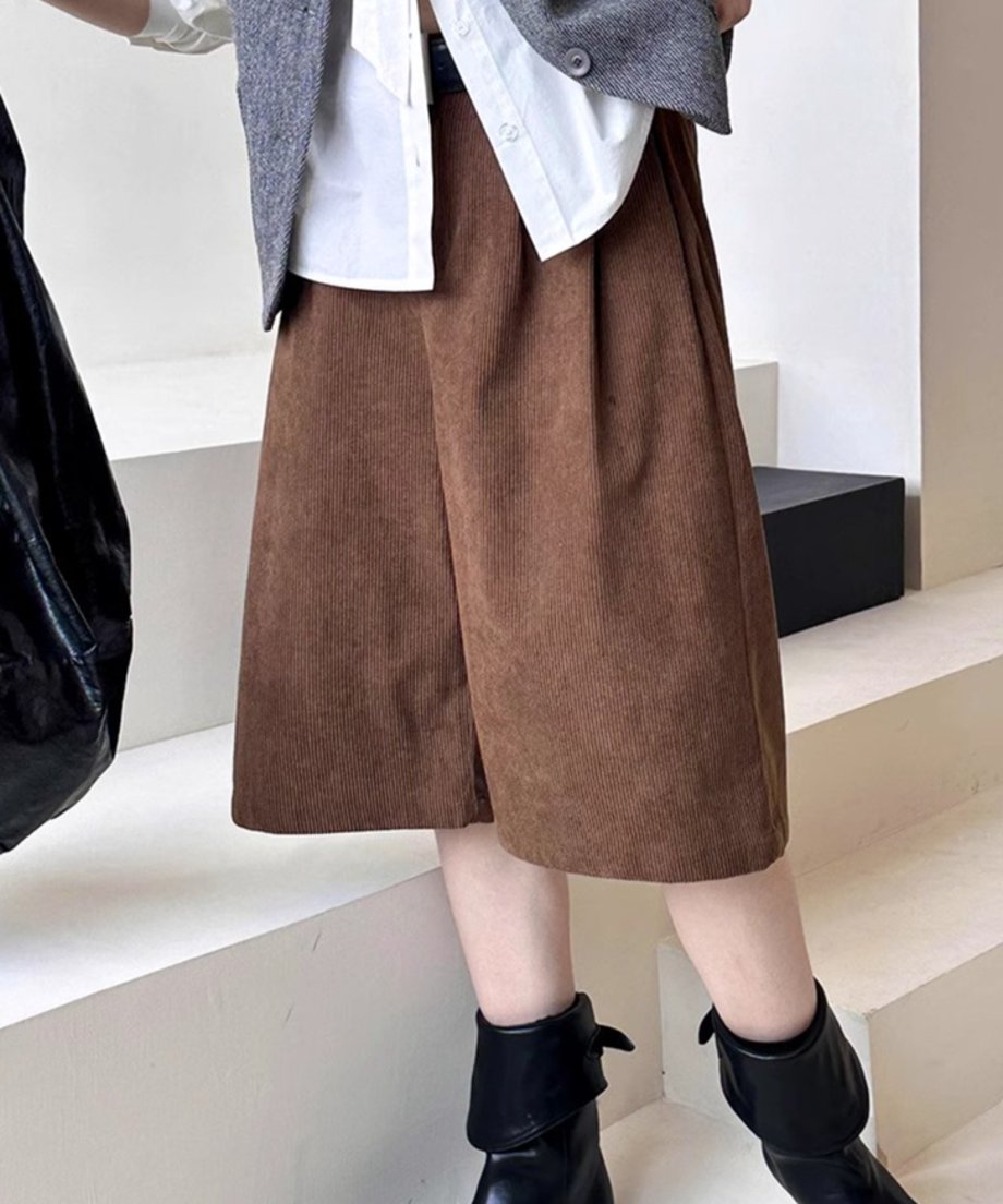 白シャツとグレーのベストに、茶色の太畝コーデュロイ膝丈ワイドパンツと黒のショートブーツを合わせた秋冬のコーディネート。