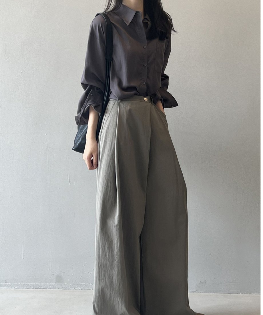 ダークグレーのルーズシャツをカーキ色のワイドパンツにインして着用している女性の全身ショット。