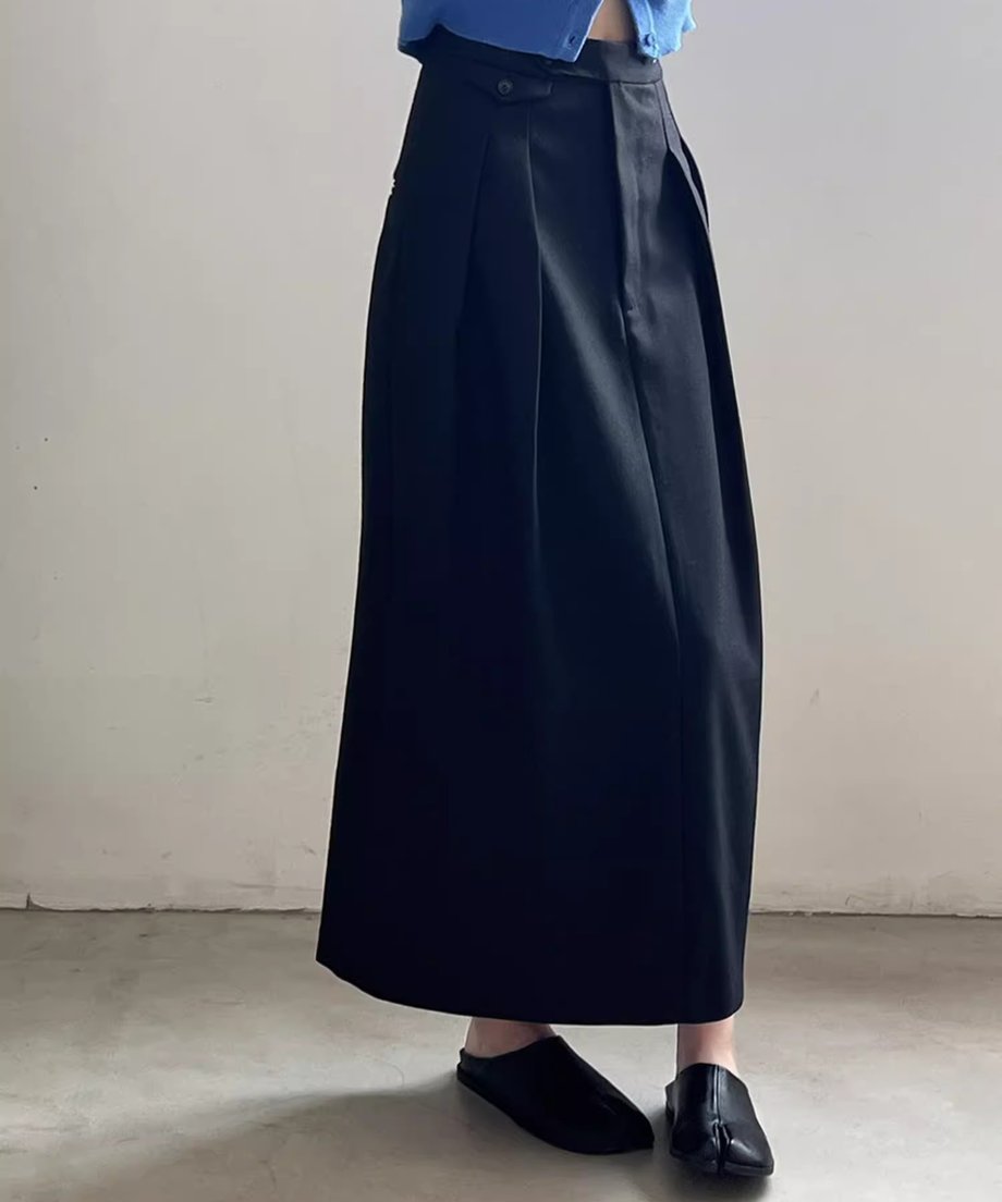 黒のストレートロングタックスカートを着用した全身の正面。タックによる立体的なシルエットが特徴。
