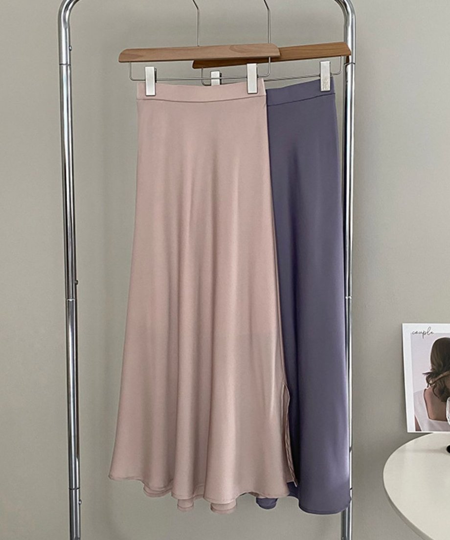 アプリコットとパープルのスカートがハンガーに掛けて並べられたショット。