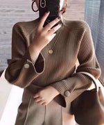 ブラウン色の細リブハイネックニットとブラウン系のトラウザーを着用した女性のクローズアップ画像。