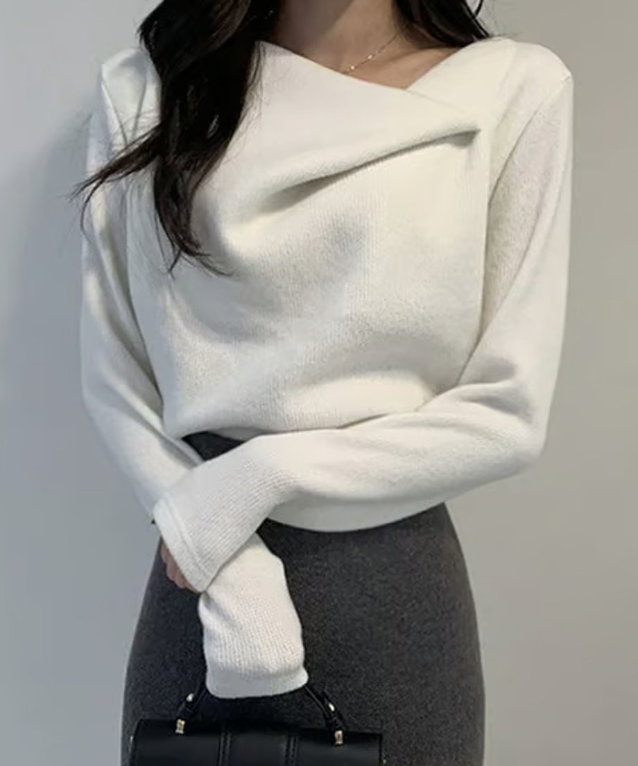 ホワイトの長袖ニットプルオーバーを着用し、チャコールグレーのタイトスカートを合わせた女性のアップ。