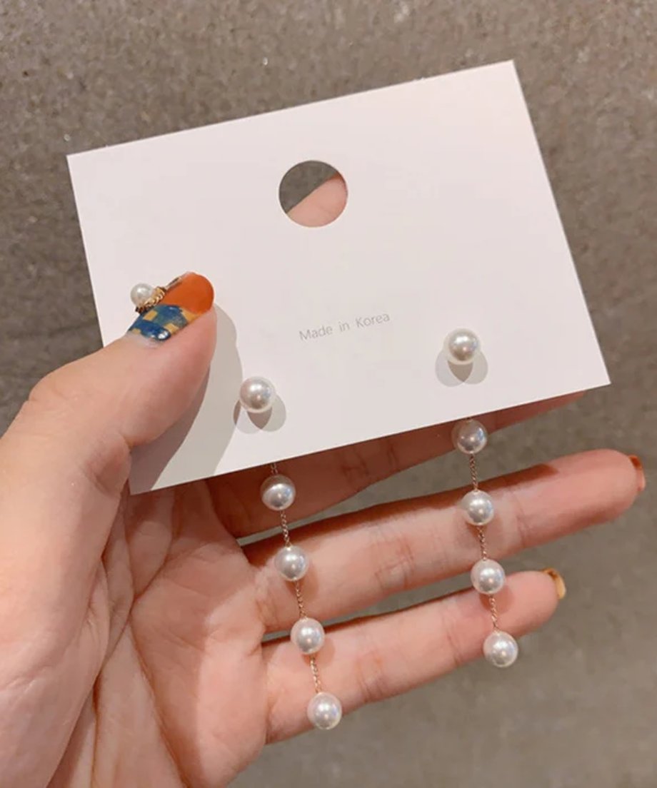 パールチェーンのロングピアスを手に持ったクローズアップ。