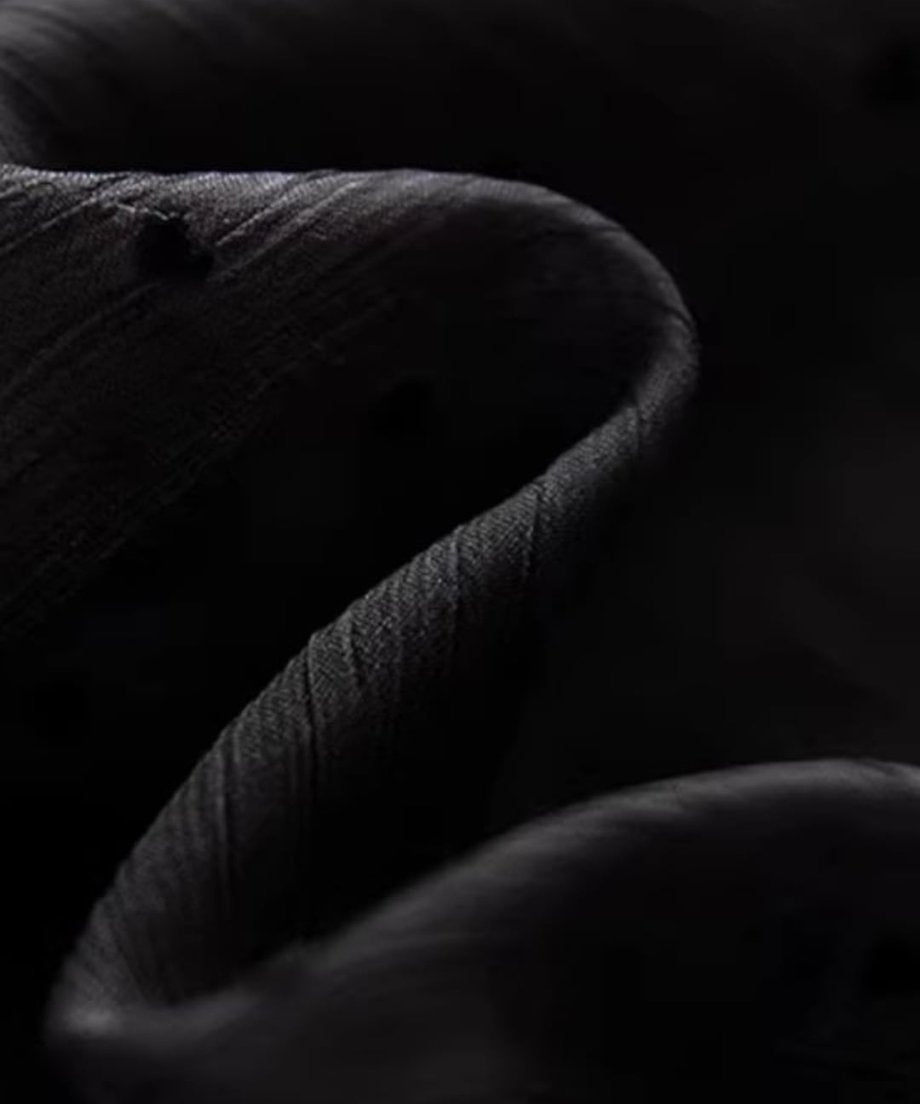 黒のシアーブラウスの生地のドレープとシワ感を写したクローズアップ。