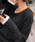 ブラックのロングスリーブTシャツの袖口のクローズアップ。袖が長めに作られており、内側に白のTシャツをレイヤードしている様子が見える。