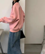 ピンクのスウェットとデニムのロングスカートを着用した女性の側面。袖のボリューム感がよく分かります。