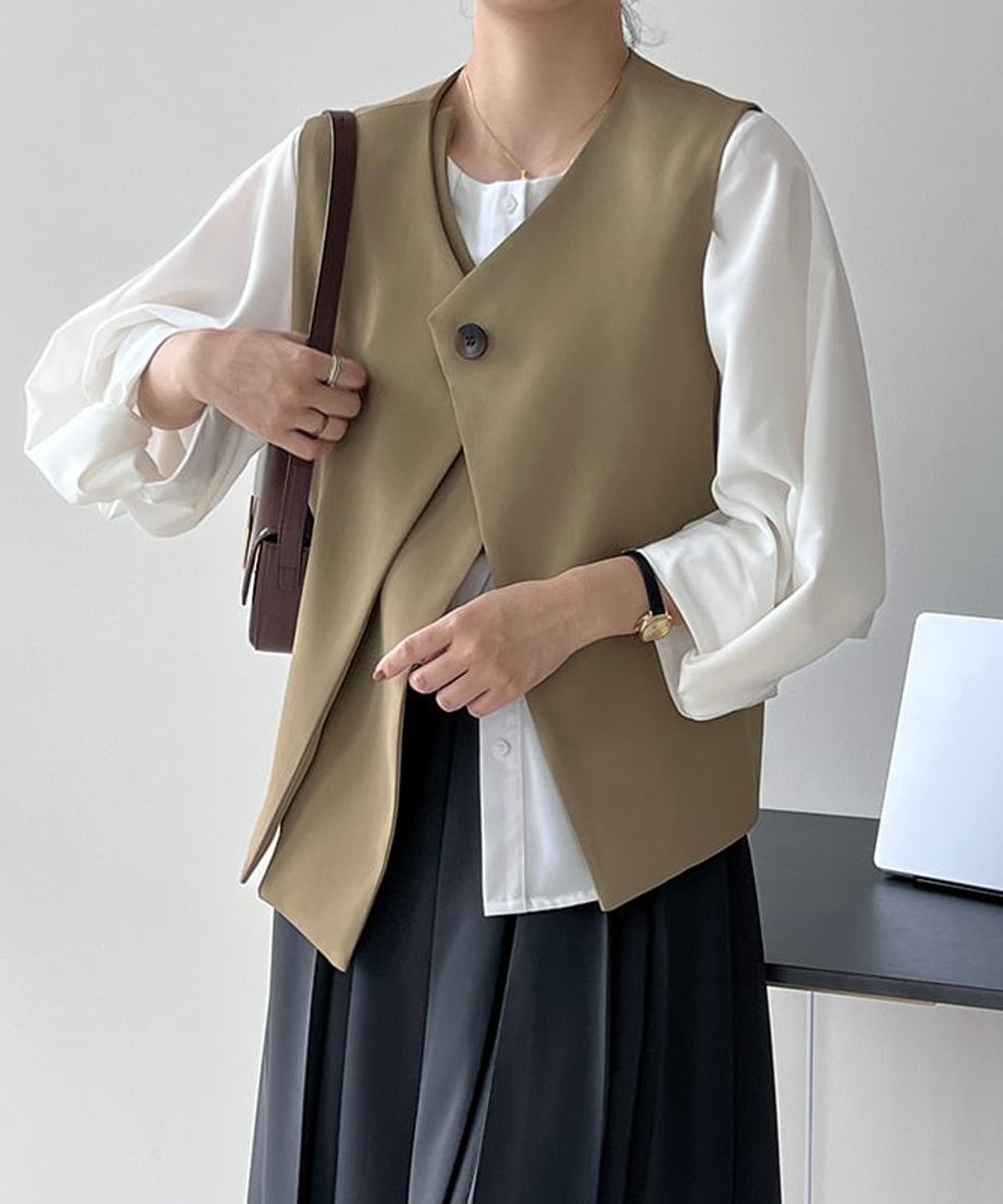 ベージュのベストを着た女性のクローズアップ。肩掛けした茶色のミニバッグが確認できる。