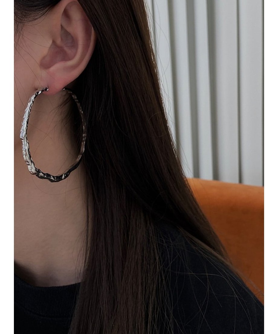 黒いトップスに合わせたシルバーのビッグフープピアス。
