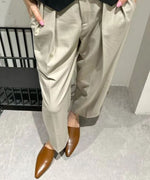 ブラウンのパンツの裾から覗く、滑らかな質感のブラウンレザーミュールのアップ写真。