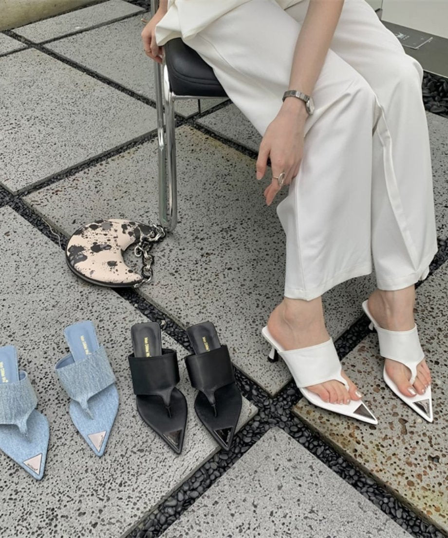 椅子に座った女性の足元に並ぶ、ブルー、ブラック、ホワイトの3色のポインテッドトゥサンダル