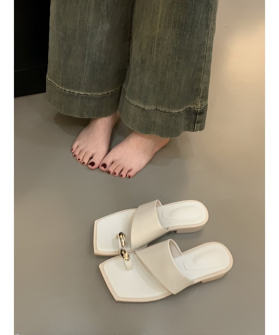 素足の横に置かれたホワイトのサンダルの比較写真。着用時のイメージが伝わる一枚。