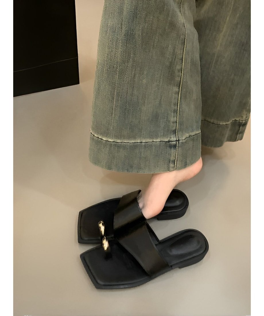 ブラックのサンダルをワイドパンツに合わせて着用した足元の写真。トレンド感のあるスクエアトゥのシルエット。