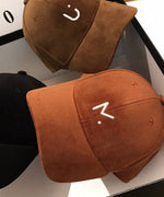 キャメルとダークブラウンのキャップを並べて上から撮影。光沢のあるコーデュロイの生地感と刺繍のディテールが確認できます。